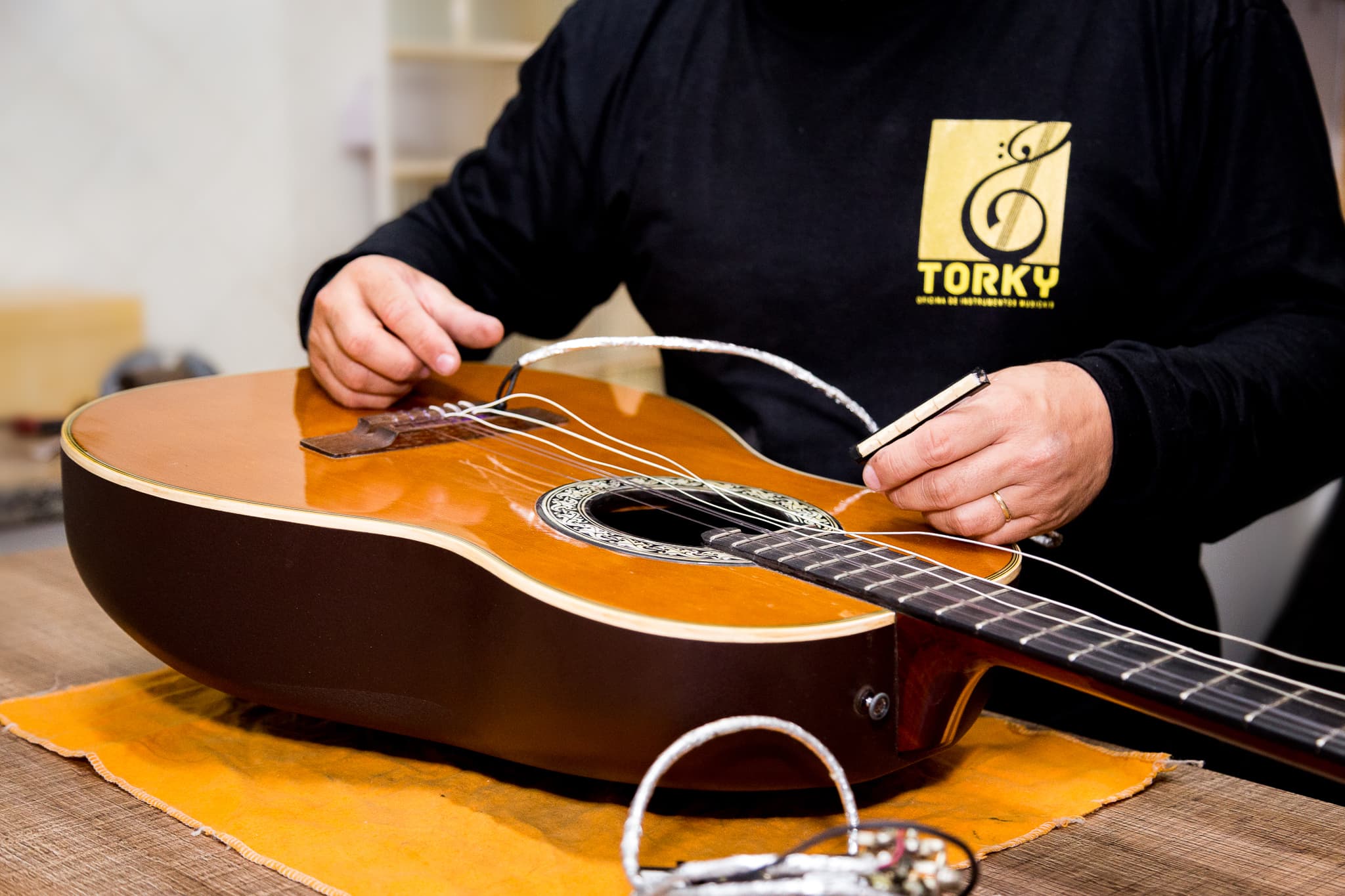 Luthier Torky trocando as cordas de um violão clássico